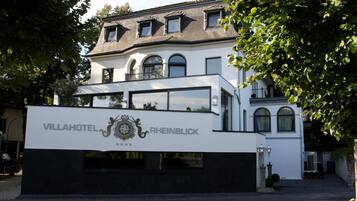 A two-story villa with a modern design, featuring a prominent sign for VillaHotel Rheinblick.