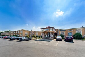 A hotel with a parking lot, a central entrance, and a clear sky. - Rodeway Inn Capri (Little Ferry)