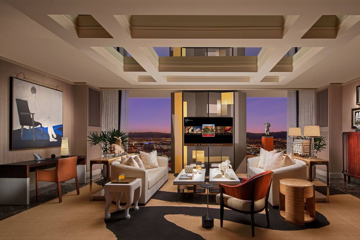 A modern living room with a city view, a large flat-screen TV, and a cozy seating area.