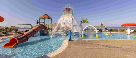 A water park with a large slide, a water fountain, and a pool area.