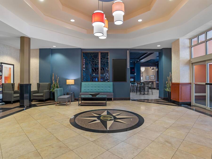 A lobby with a central seating area, a large window, and a decorative floor design.