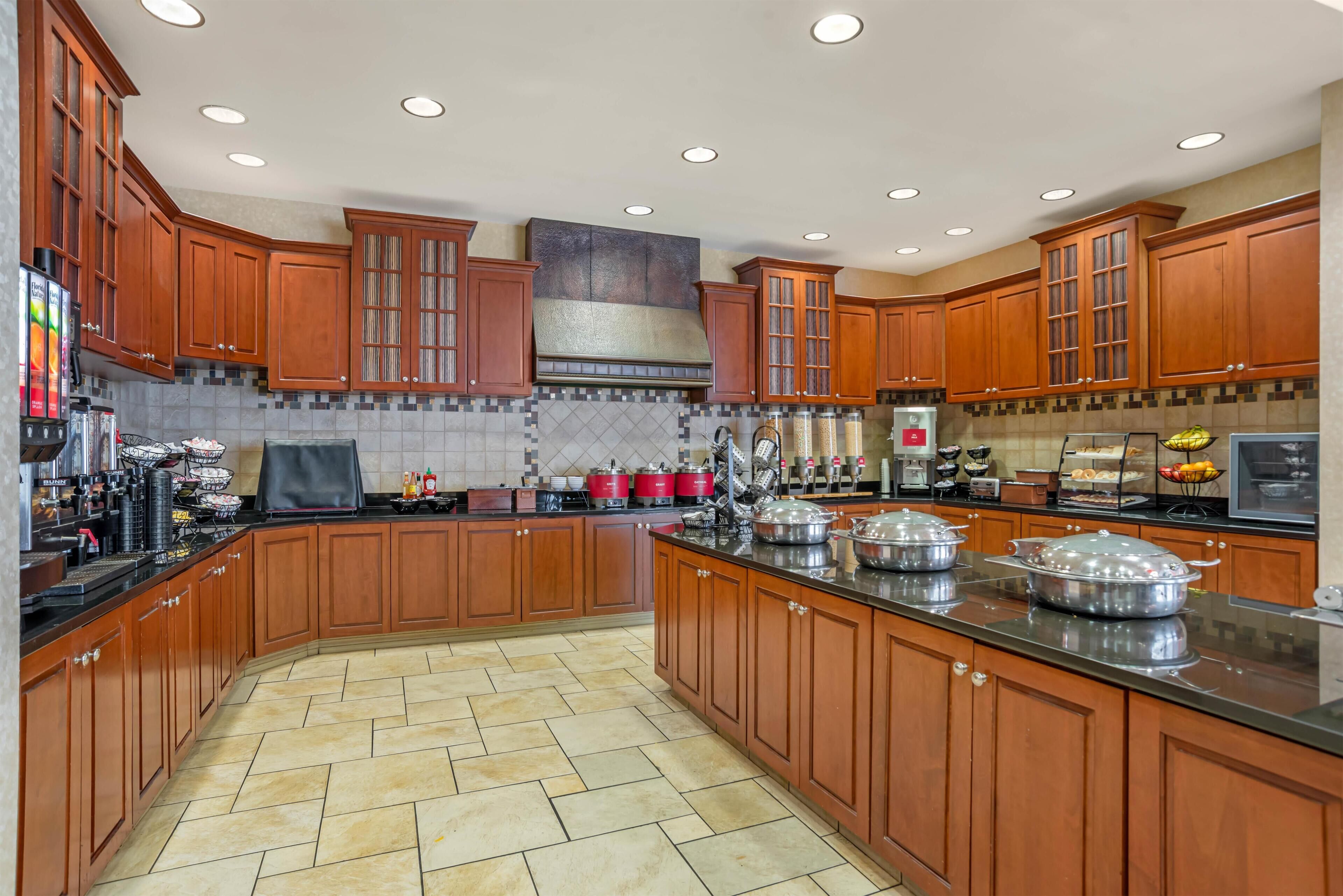 Una cocina amplia con armarios de madera, una isla central y salpicadero de azulejos.