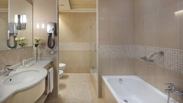 Ein modernes Badezimmer mit zwei Waschbecken, einer Badewanne und einer Dusche.