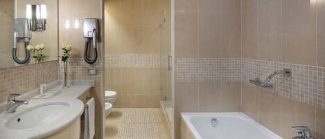 Un baño moderno con dos lavamanos, una bañera y una ducha.