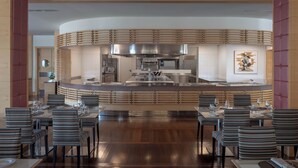 A modern restaurant with a central bar, wooden slatted ceiling, and striped chairs. - UNA Hotels Expo Fiera Milano (Pero)