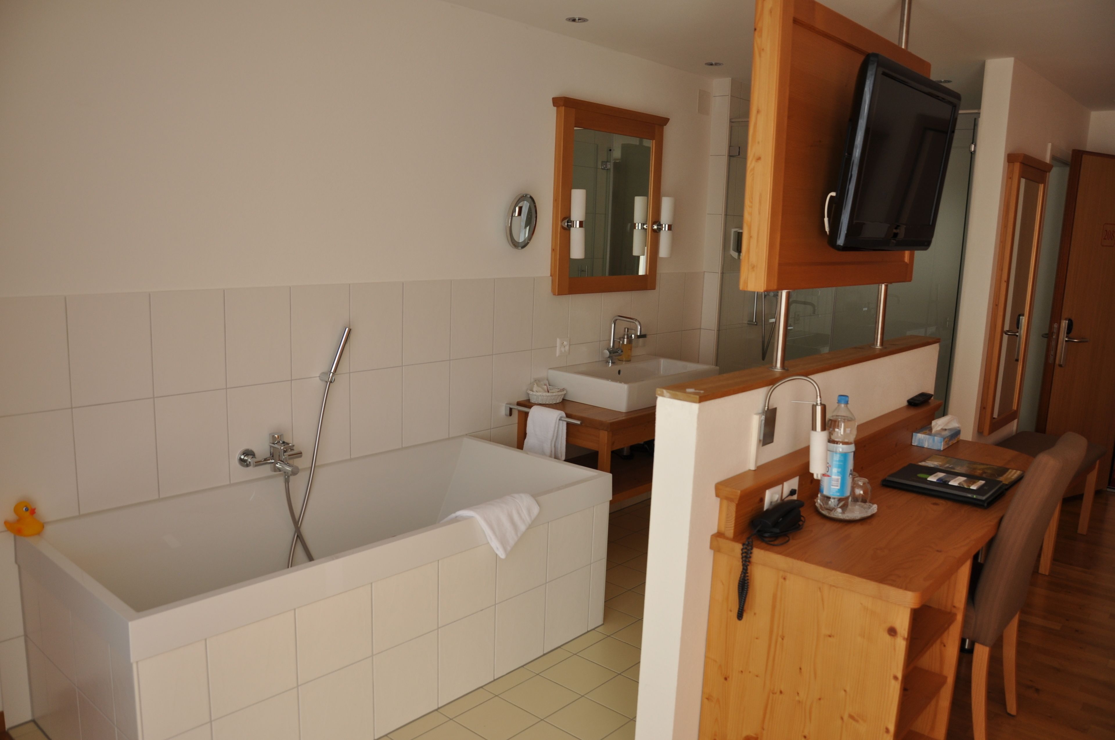 A bathroom with a bathtub, sink, and wooden vanity.