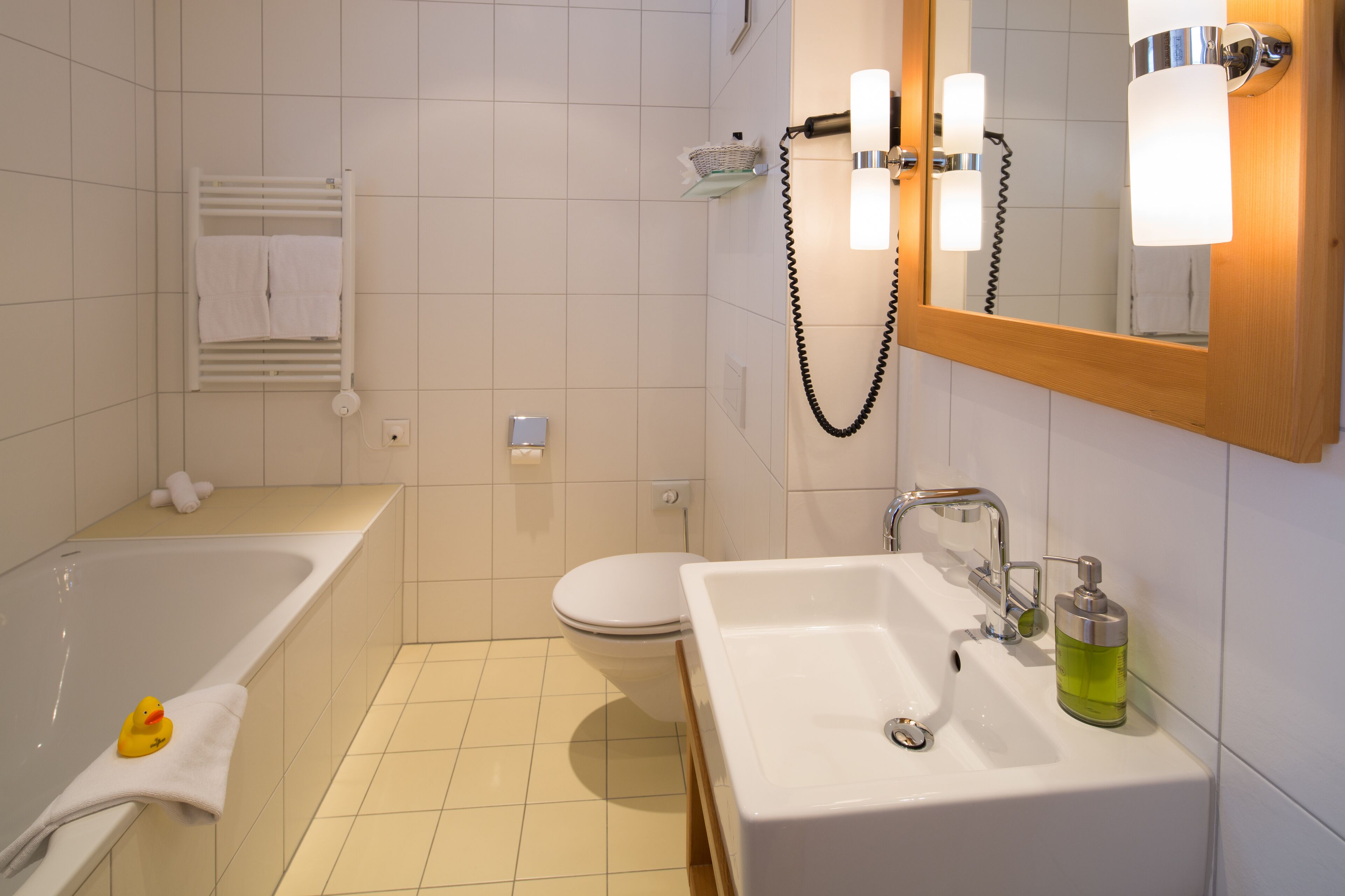 A modern bathroom with a bathtub, toilet, and sink.