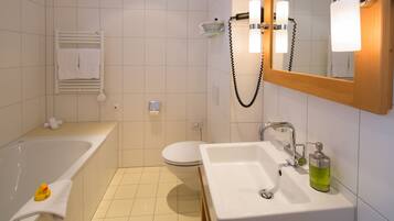 A modern bathroom with a bathtub, toilet, and sink.