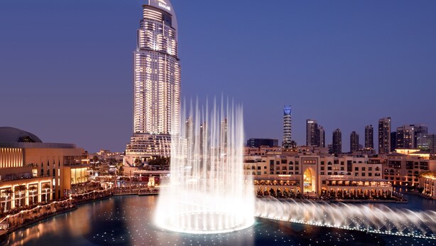 A cityscape with a prominent tower and a fountain.