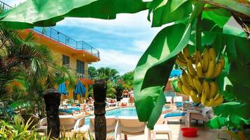 A poolside area with lounge chairs and a building in the background.
