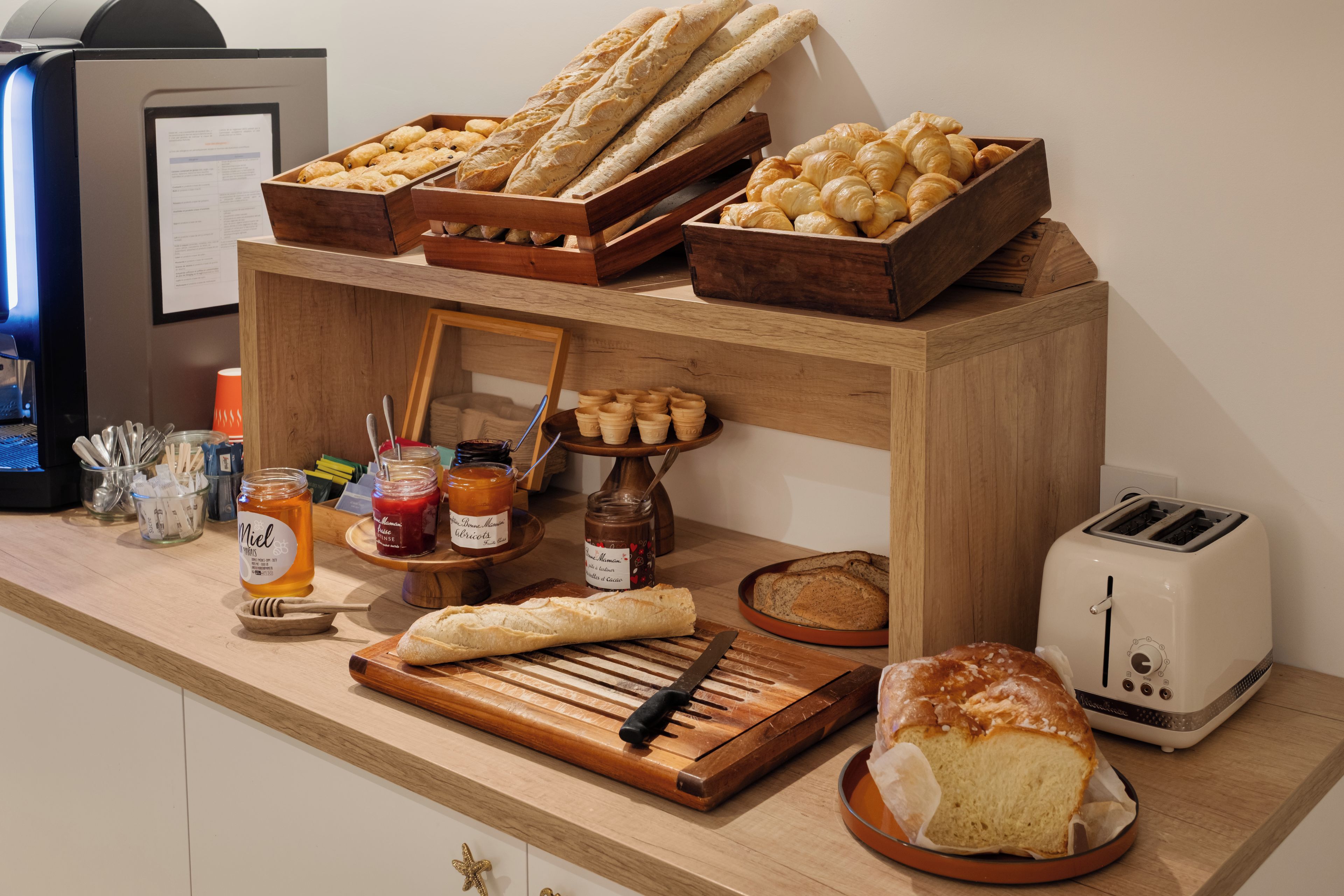 Een ontbijtbuffet met brood, gebak en jam.