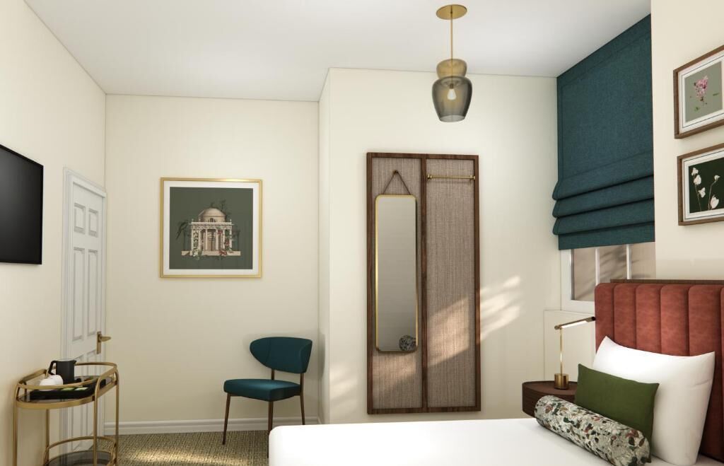 Habitación de hotel con cama, una silla, mesita de noche, lámpara, espejo, armario y un cuadro en la pared.