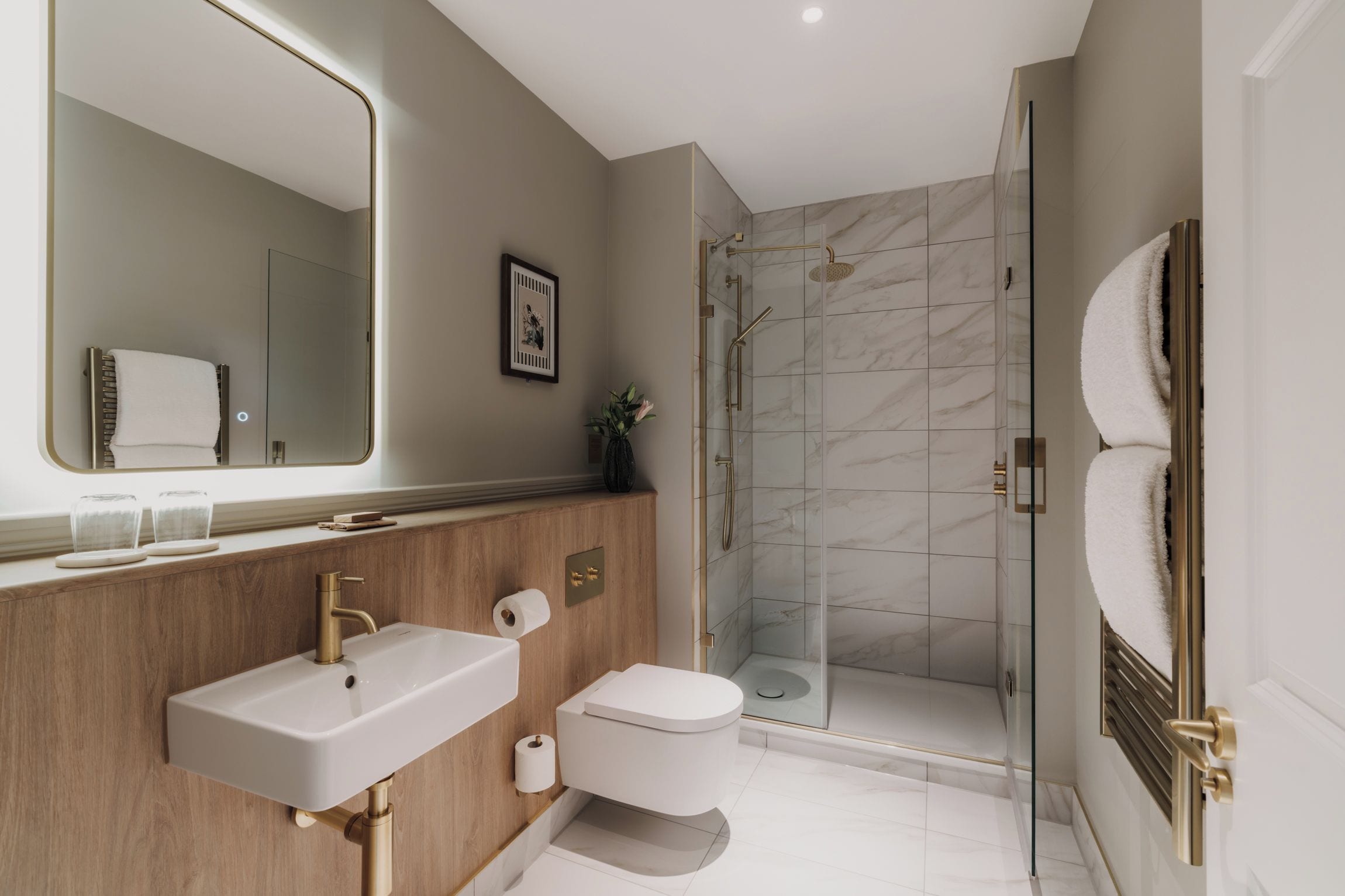 A modern bathroom with a large mirror, a wooden vanity, a white sink, a toilet, and a glass-enclosed shower.