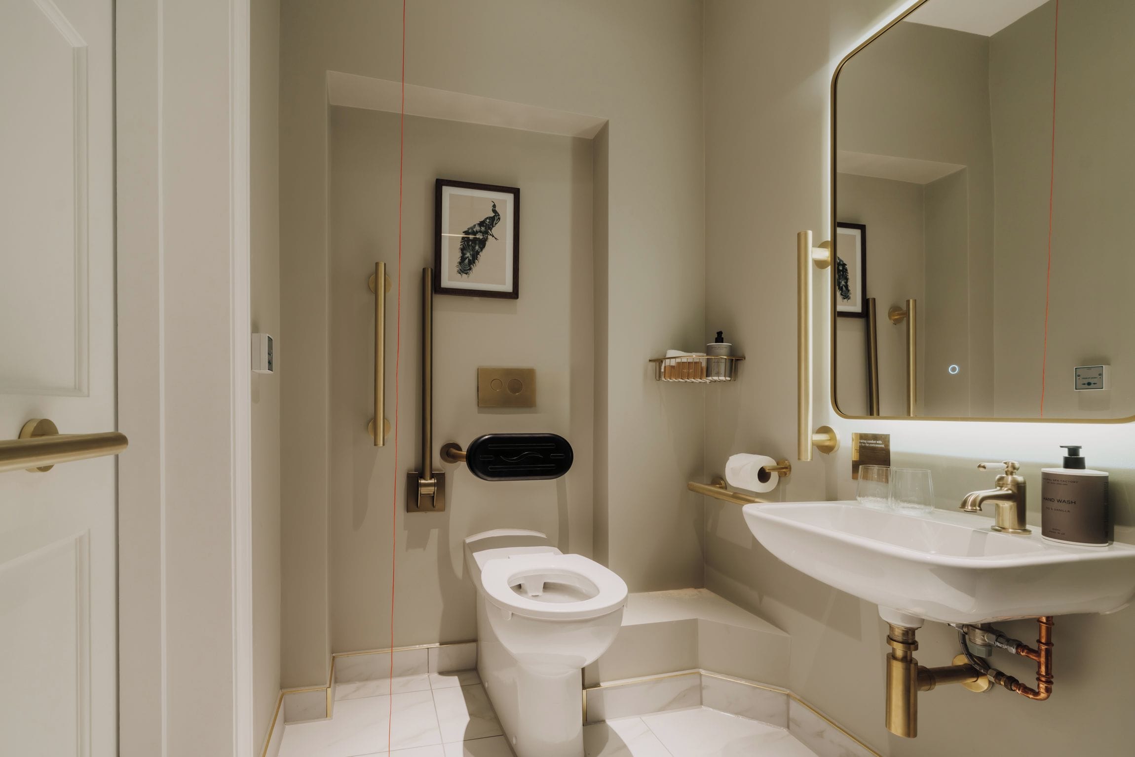 Ein modernes Badezimmer mit Toilette, Waschbecken und Spiegel.