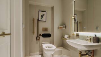 Ein modernes Badezimmer mit Toilette, Waschbecken und Spiegel.