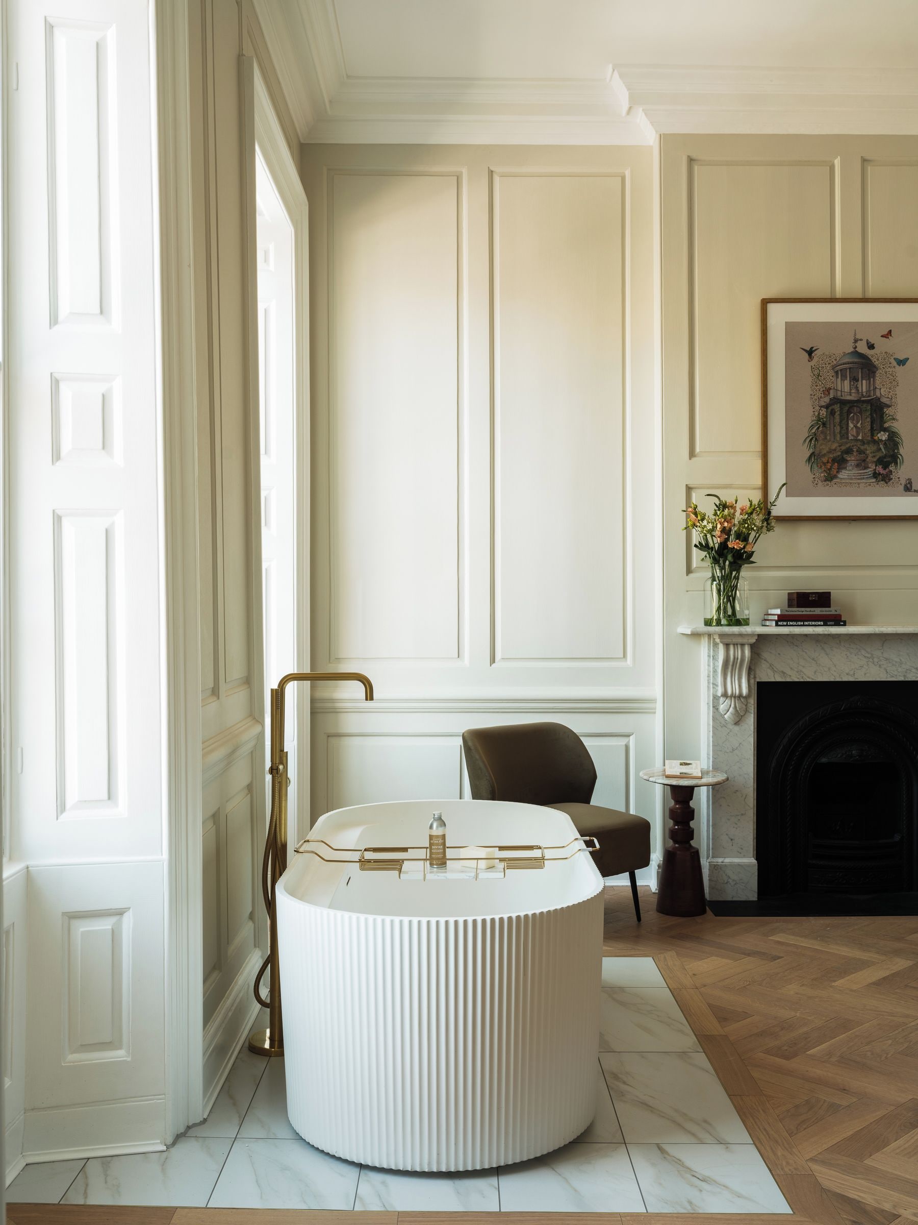 A room with a round white table, a fireplace, and a framed picture on the wall.