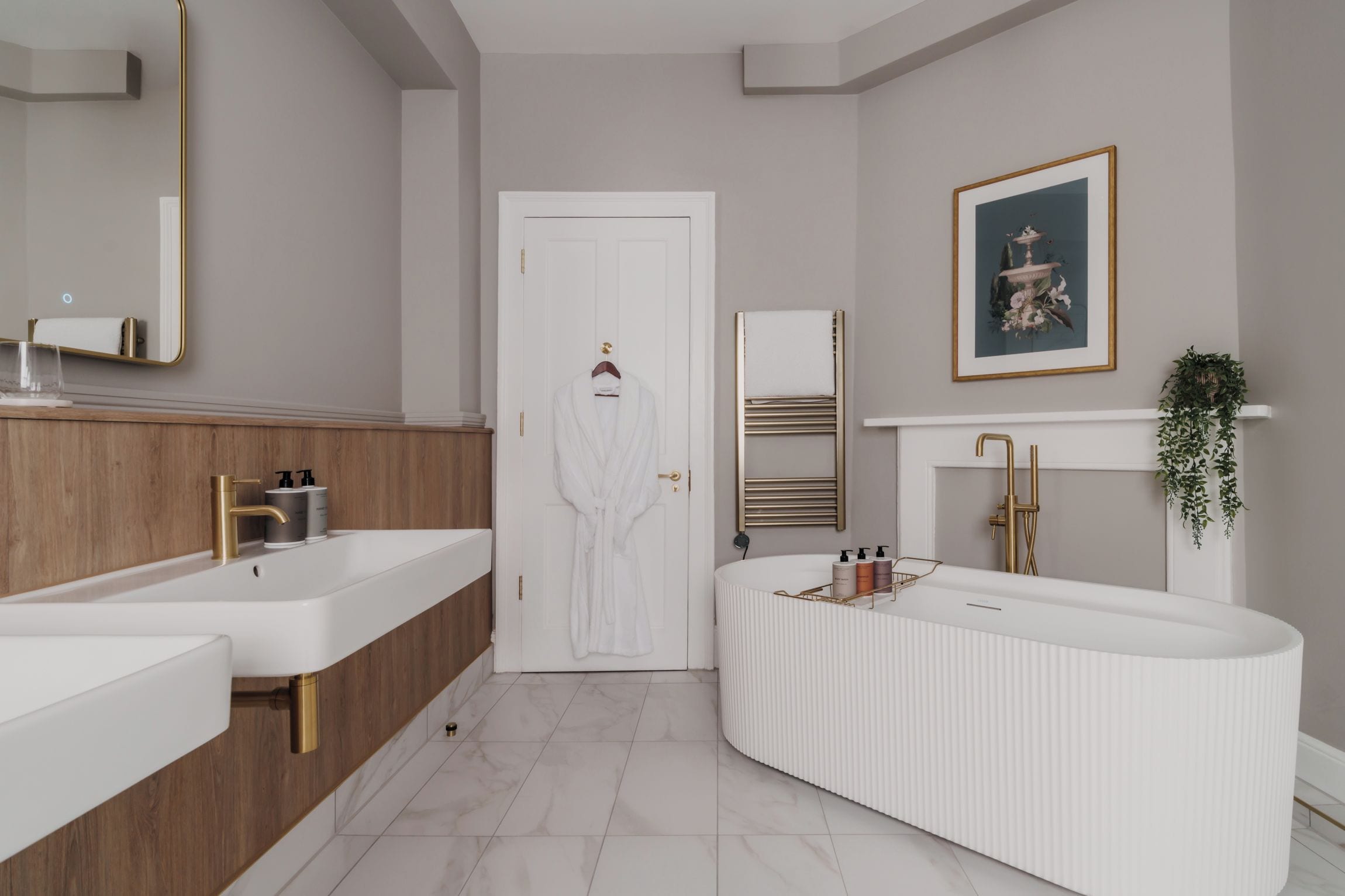 Un baño moderno con lavamanos dobles, un espejo grande y un mueble de tocador con toallero.