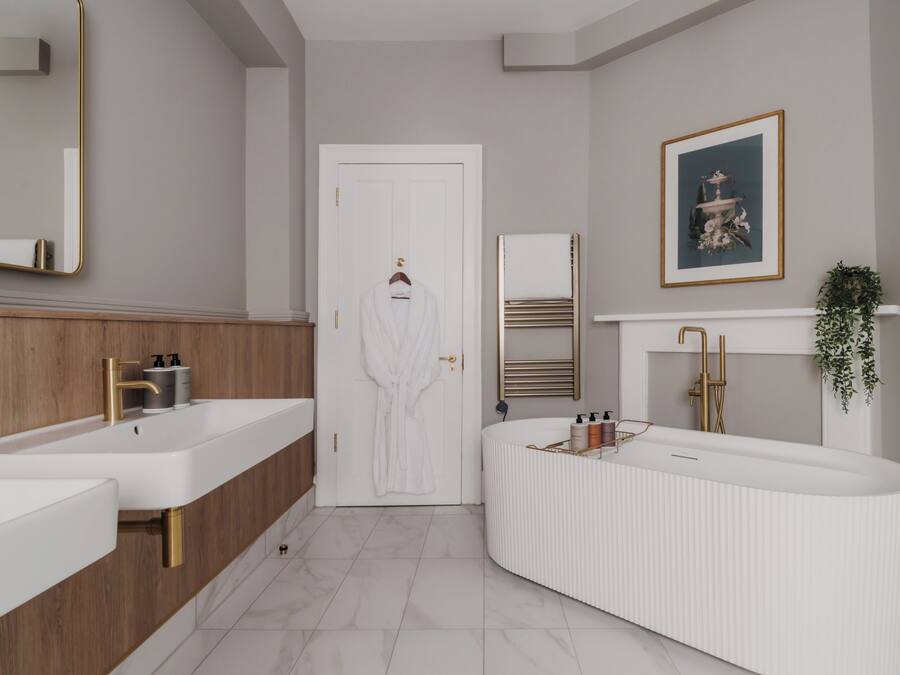 Un baño moderno con lavamanos dobles, un espejo grande y un mueble de tocador con toallero.