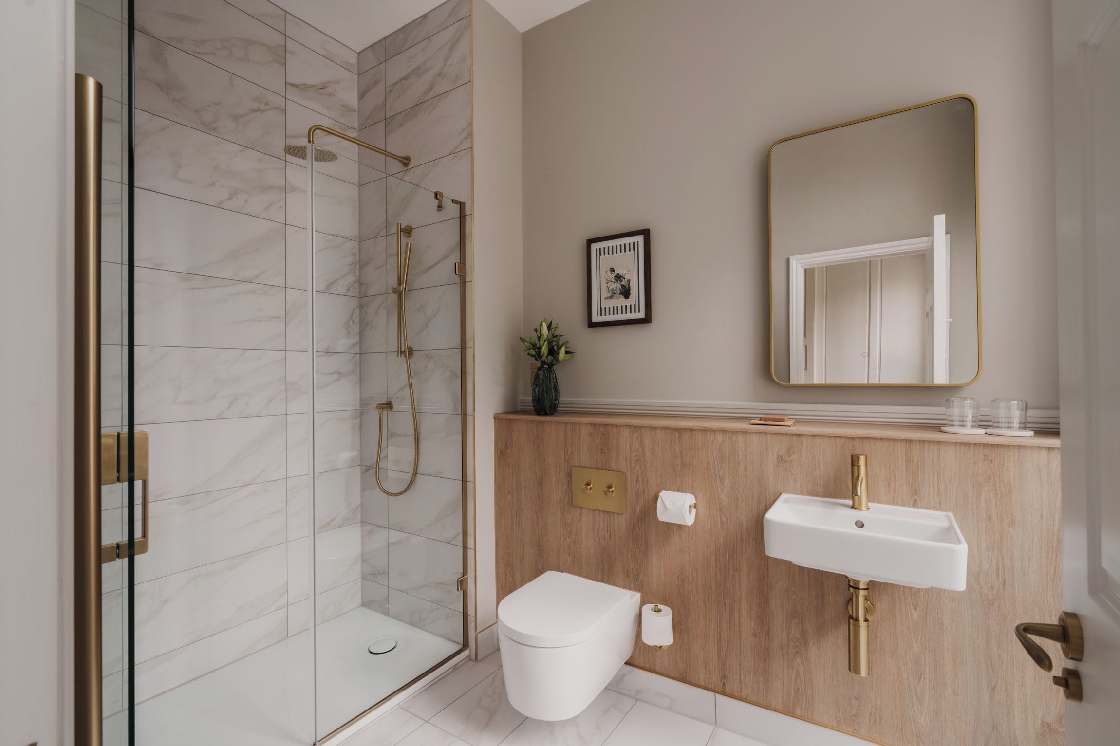 A modern bathroom with a glass-enclosed shower, a wooden vanity with a sink and mirror, and a toilet.