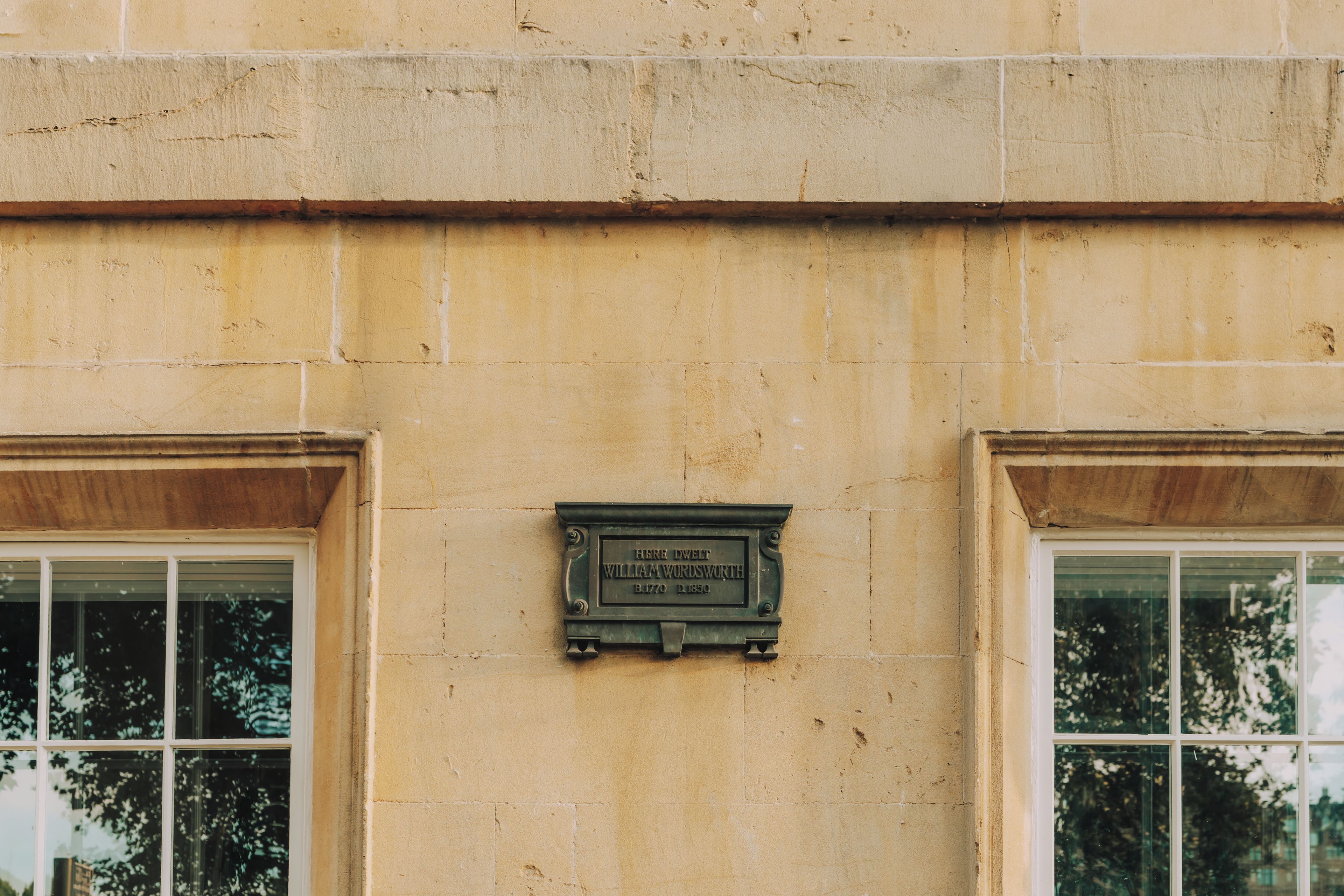 A building facade with a plaque indicating the name and dates.
