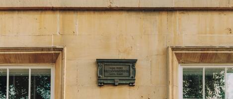 A building facade with a plaque indicating the name and dates.