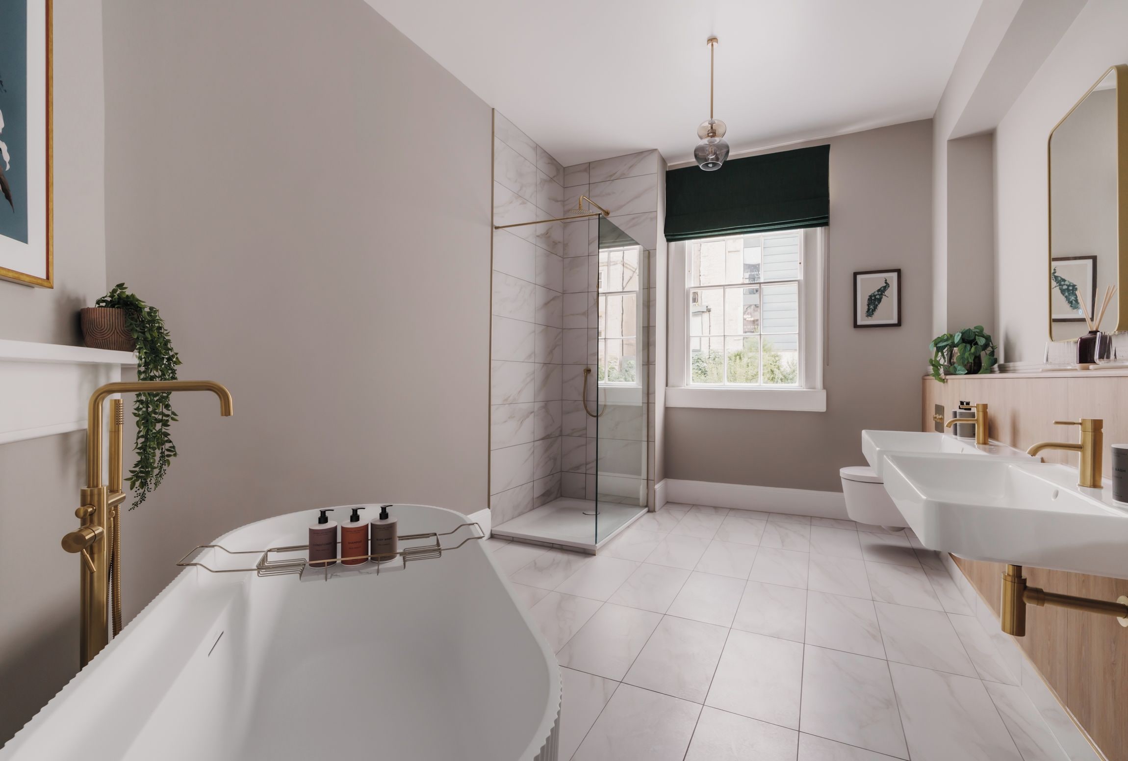 A modern bathroom with a freestanding bathtub, a glass-enclosed shower, and a vanity with dual sinks.
