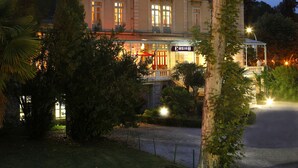 Un hotel de varios pisos con un estilo arquitectónico clásico, que cuenta con balcones y grandes ventanales.