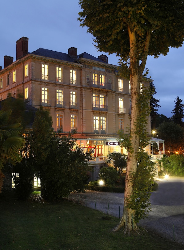 Un hotel de varios pisos con un estilo arquitectónico clásico, que cuenta con balcones y grandes ventanales.