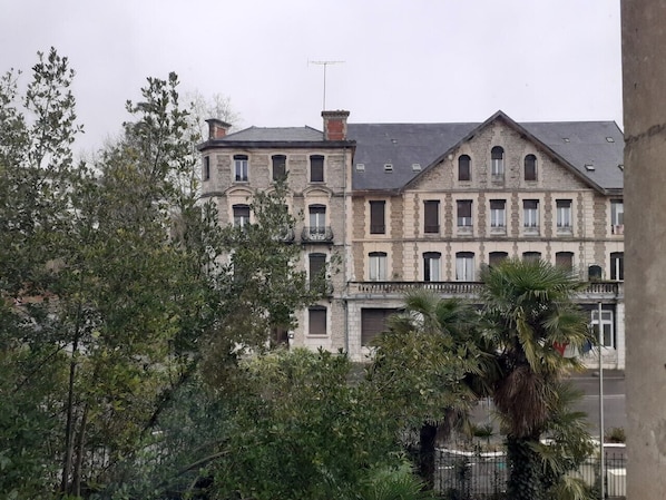 Un edificio de varios pisos con fachada simétrica, que presenta una entrada central con balcón.