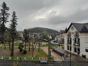 Un edificio con una torre de reloj, rodeado de árboles y un parque.