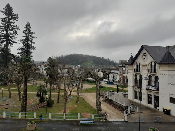 A building with a clock tower, surrounded by trees and a park area.