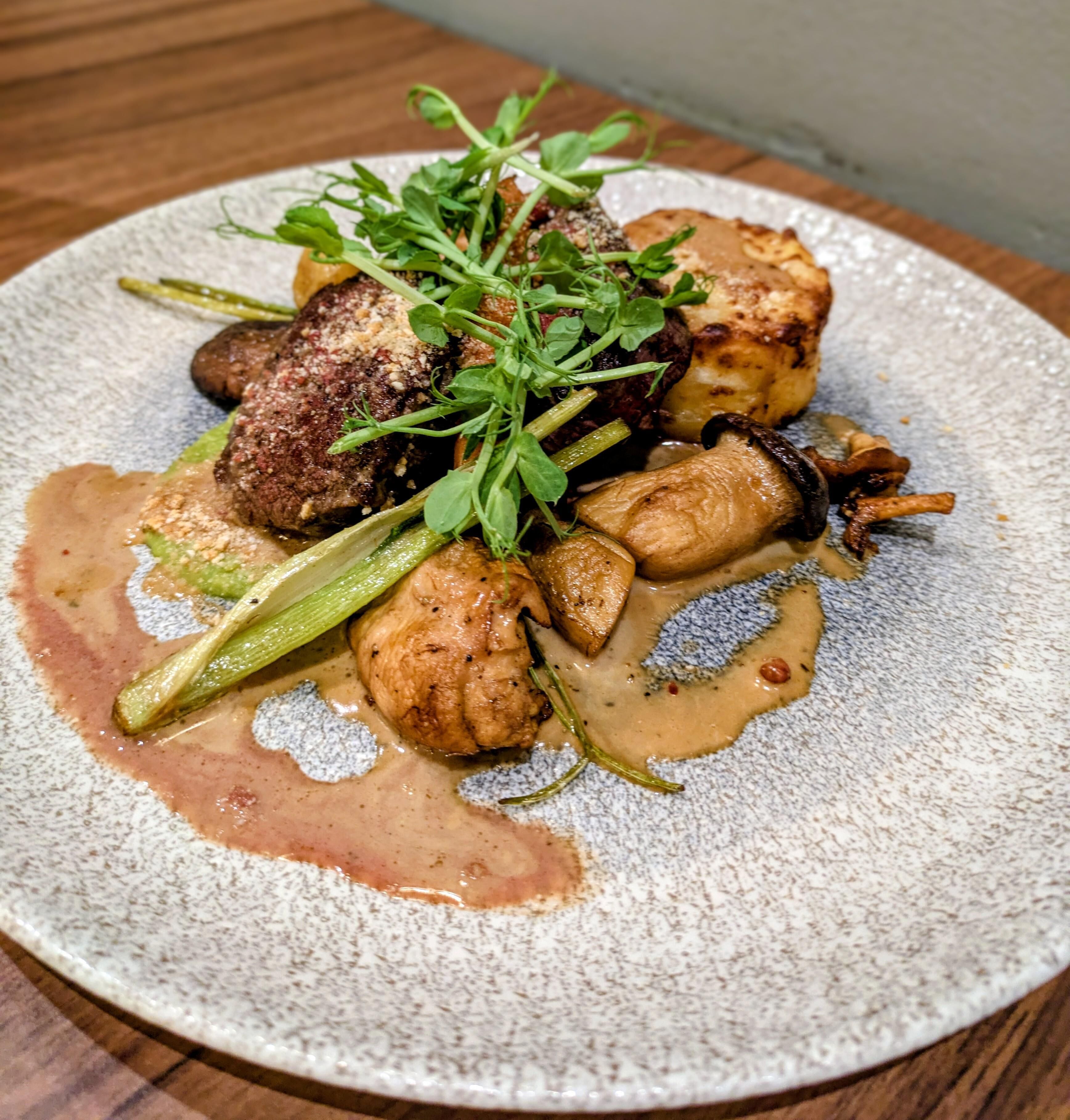 Un plato de comida con varias verduras y salsa cremosa.