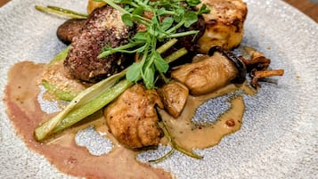 Un plato de comida con varias verduras y salsa cremosa.