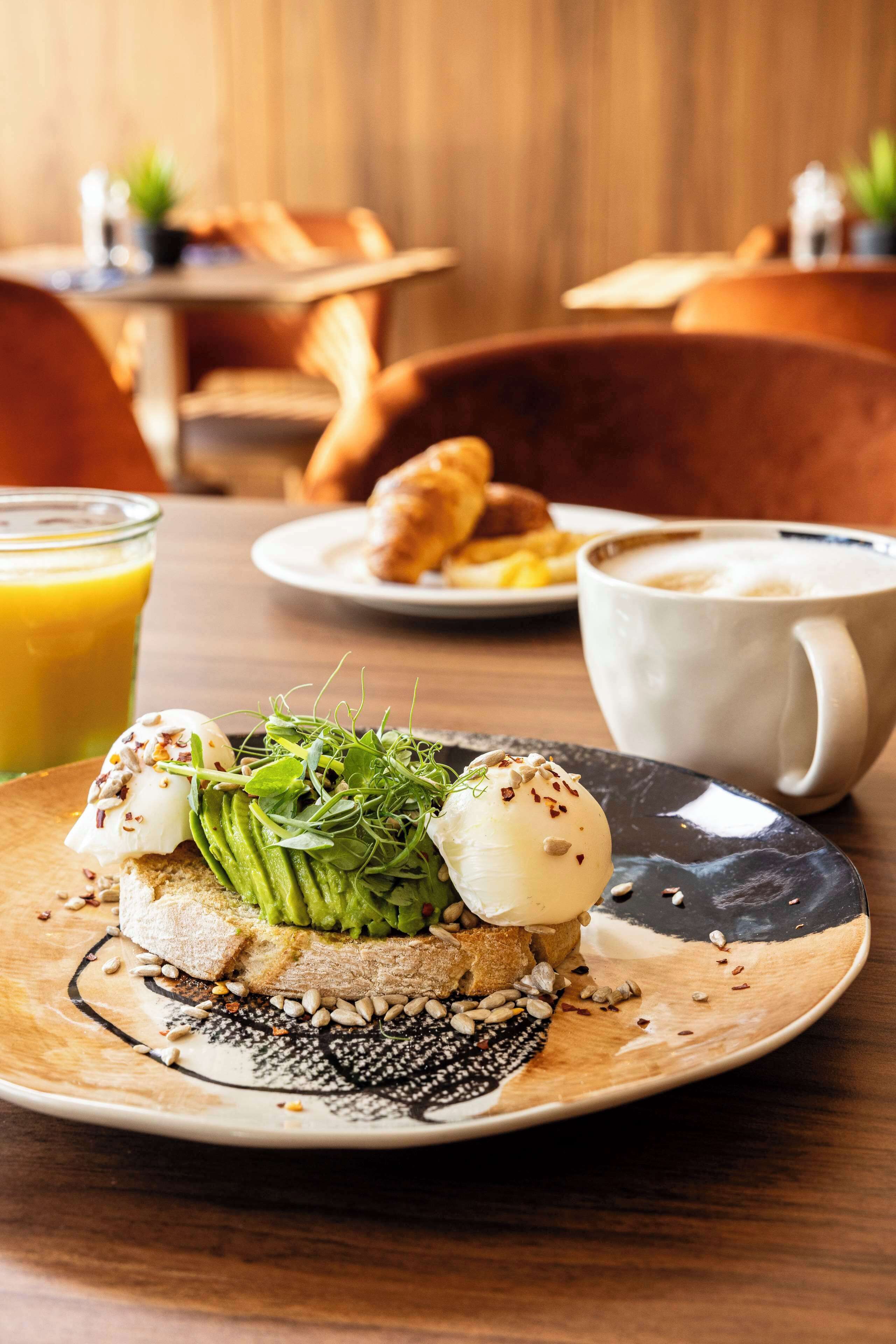 A breakfast setting with a plate of food, a glass of orange juice, and a cup of coffee.