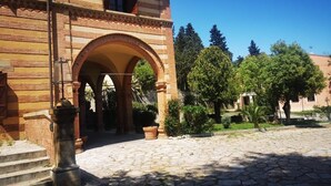 Un patio con un sendero de piedra que lleva a un edificio con una entrada arqueada.