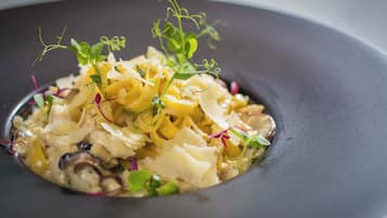 A plate of pasta with greens and cheese.