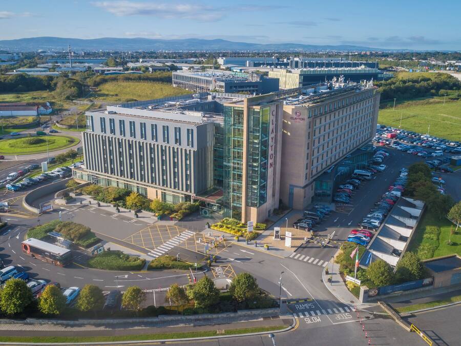 A modern building with a parking lot and a roundabout.