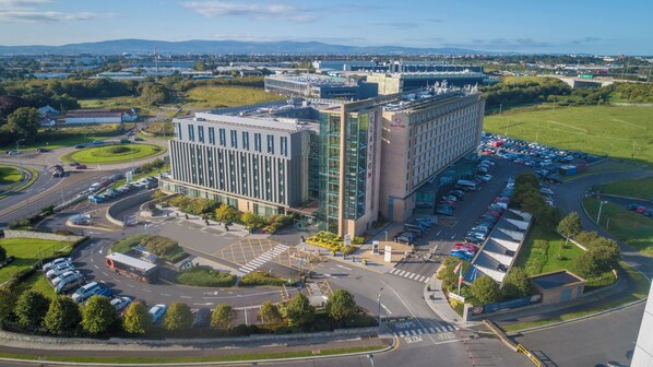 A modern building with a parking lot and a roundabout.