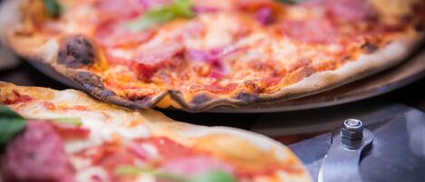 Une pizza avec des ingrédients bien visibles et un coupe-pizza sur un plateau.