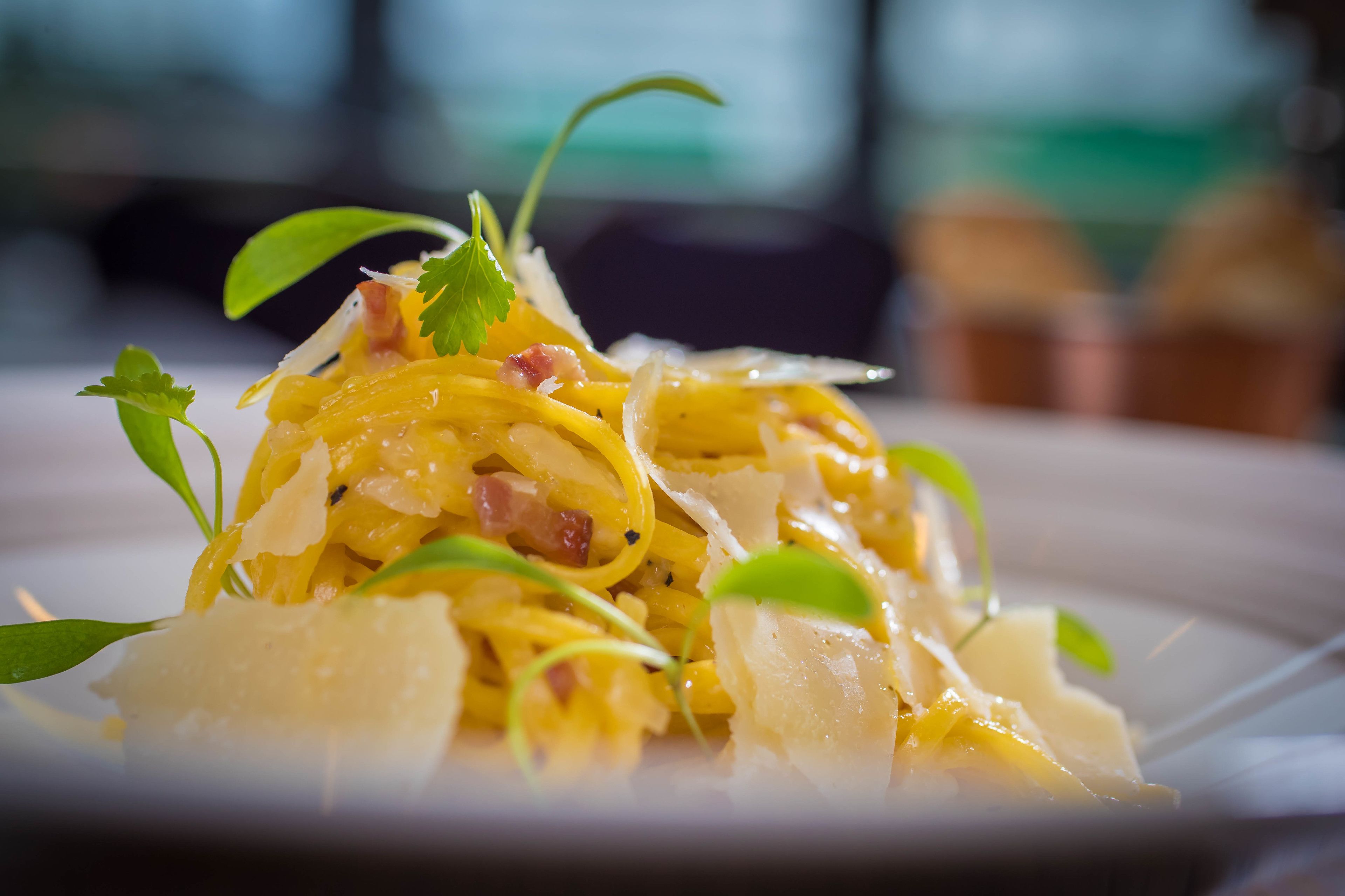 A close-up of a pasta dish with garnishes.