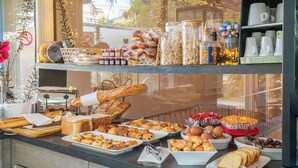 A breakfast buffet with various pastries, breads, and condiments. - Hotel Diana (Vence)