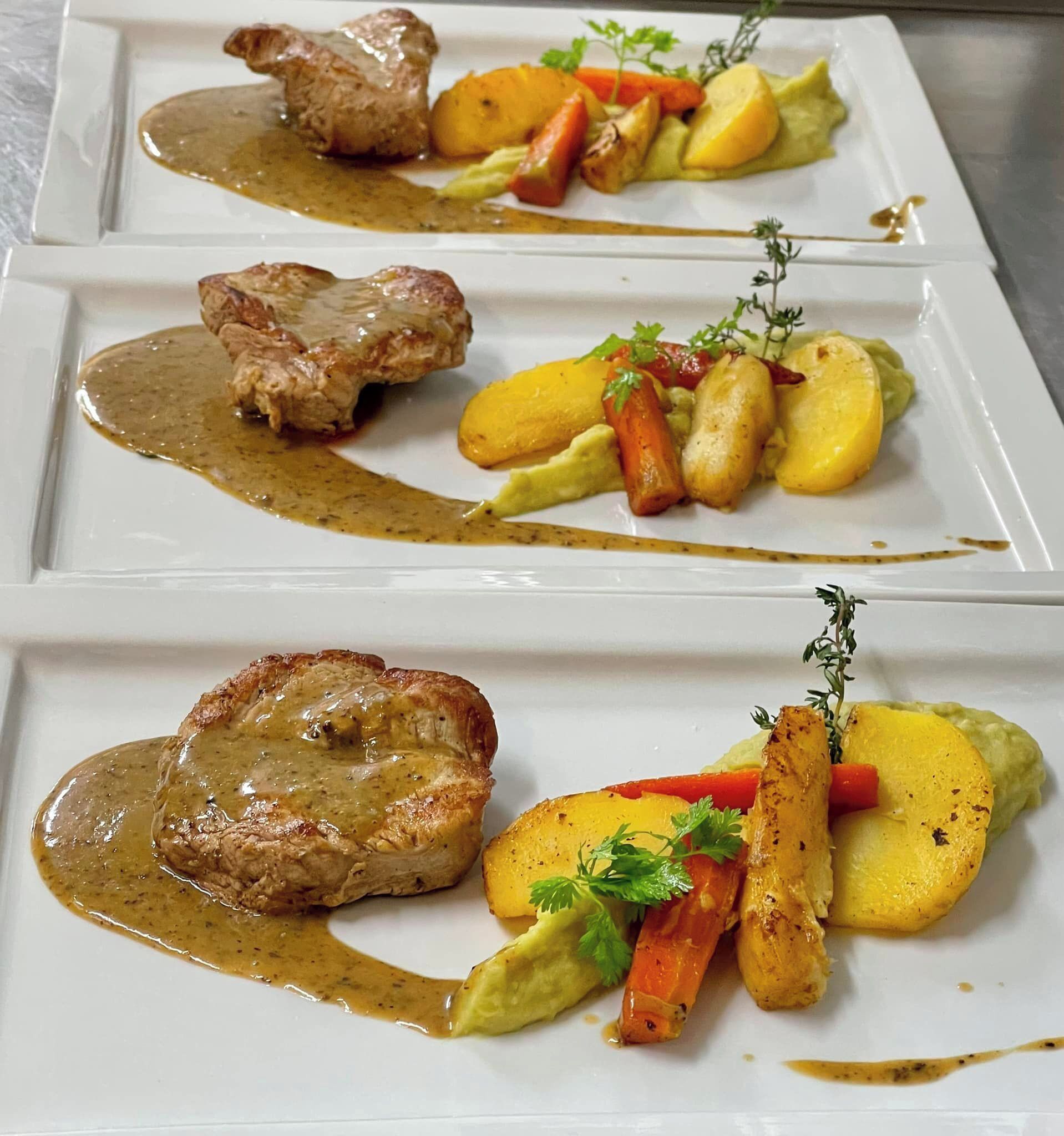 A plated dish with meat, vegetables, and sauce.
