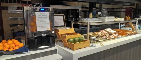 Ein Buffetbereich mit verschiedenen Speisen, darunter Obst, Soßen und Getränke.