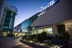 A modern building with a prominent 'Zenith' sign, featuring a glass facade and a well-lit entrance. - Zenith Hotel Conference & Spa (Constanta)