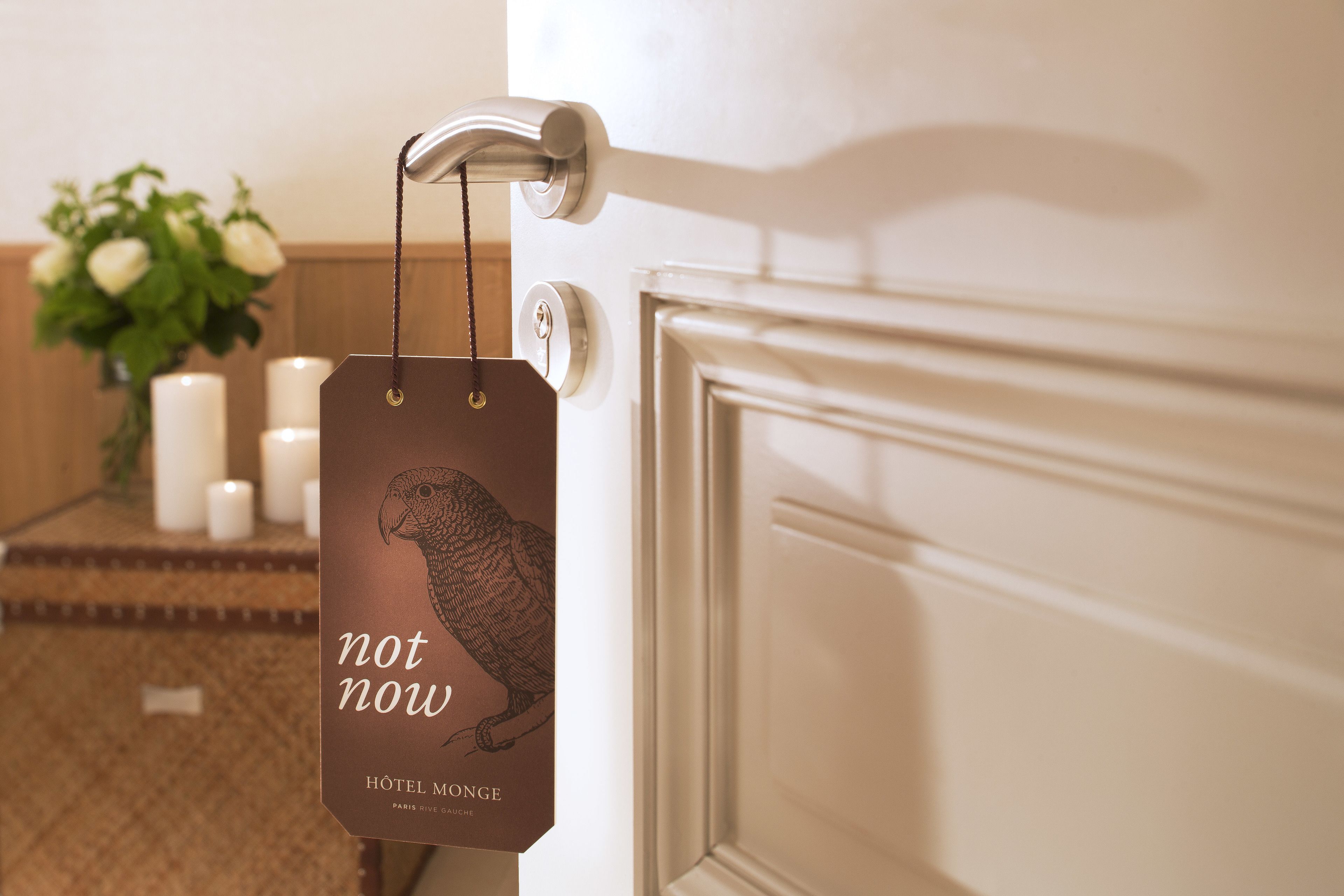 Une porte sur laquelle est accrochée une étiquette indiquant « pas maintenant » et « HÔTEL MONCE PARIS ».