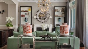 A sophisticated living room with a green sofa set, a decorative mirror, and a unique chandelier. - Hotel Monge (Paris)