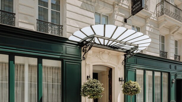 A classic hotel facade with ornate balconies, a prominent entrance with a canopy, and a sign indicating it is the Hotel Monge. - Hotel Monge (Paris)