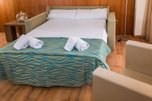 A hotel room with a bed, a small table with a decorative item, and a chair. - RVHotels Nautic Park (Castell-Platja d'Aro)