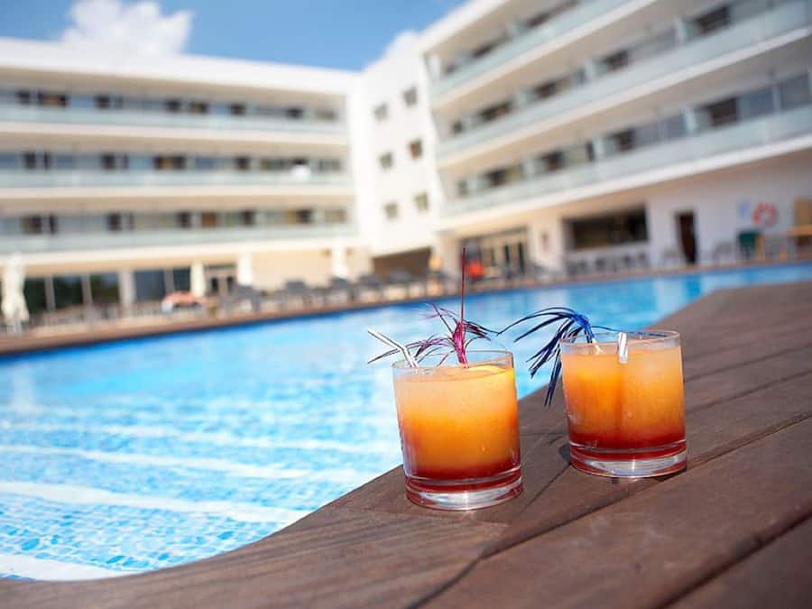 Una piscina al aire libre, sillones reclinables de piscina
