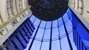 Un atrio de varios niveles con techo estrellado y suelo de cristal.